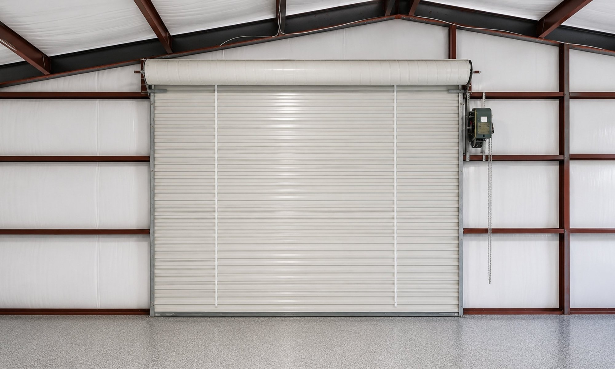 Commercial roll-up steel door installed inside a metal warehouse building.